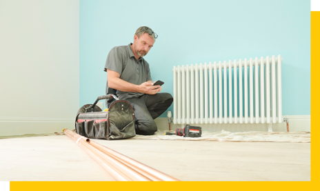 heating and gas engineer installing radiator