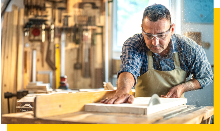 carpenter using saw bench to cut timber