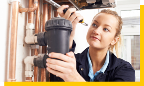 female heating and gas engineer repairing boiler