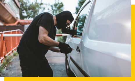 thief in balaclava trying to break into van